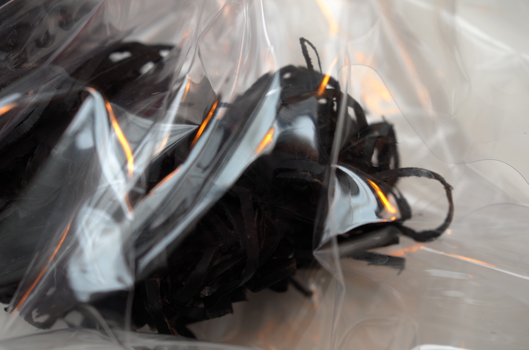Detail of a black sculpture with plastic.